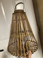 Overall view of wooden slat lantern showing teardrop shape and handle