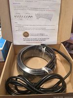 Coiled heat cable in open box with attached cord and instructions