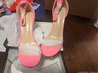 Top view of both pink high heel sandals in box