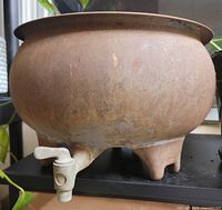 Side view showing bowl shape, spigot, and feet
