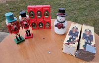 Overview of lot showing two nutcrackers, six red boxes, snowman, nutcracker packaging