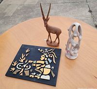 Overall lot on table: wood antelope, stone sculpture, inlay picture