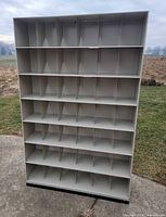 Full front view of tall grey cubby shelf showing all compartments