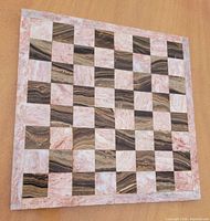 Top view of marble chess board showing pink and brown squares