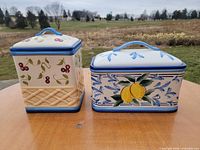 Front view of both ceramic jars showing motifs and lids