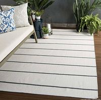 Full view of ivory rug with dark grey stripes in styled room setting