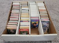Top view of four-row cardboard card storage box filled with trading cards