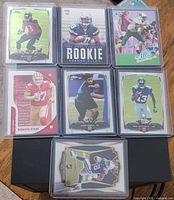 Front view of seven sleeved rookie cards laid out