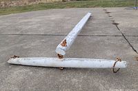Full view of wooden ox yoke laid on concrete showing length and rusty rings