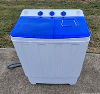 Front view of portable twin-tub washing machine with closed blue lids