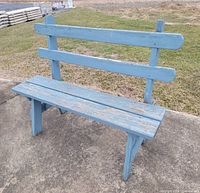 Full front view of blue wooden bench on concrete