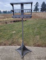 Full view of tall freestanding metal rack showing umbrella holders and triangular base