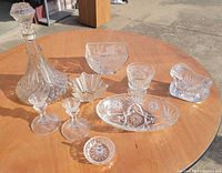 All nine clear glass pieces arranged on table outdoors