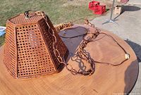 Full view of hexagonal woven bamboo light with long cord on table