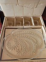 Box interior showing four cups in compartments and one plate