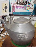 Front view showing embossed John Wright logo, spout, handle, overall condition