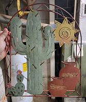 Front view of full metal wall art showing cactus, sun, pots, small cactus
