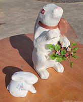 Paper mache bunny and ceramic rabbit coin bank together on table