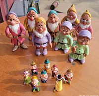 Group of eight larger dwarf figurines with nine small ornaments in foreground