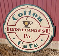 Front view of Cotton Cafe round wooden sign showing full design and text