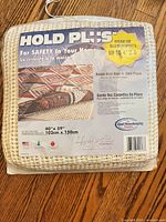 Front of sealed Hold Plus rug pad showing size and features