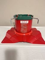 Full view of red metal base and green reservoir