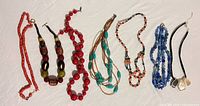Seven necklaces with beads in red, turquoise, blue and coral tones