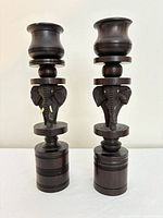 Front view of both ebony candlesticks showing elephant carvings and overall form