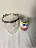 Ice bucket beside can for scale, showing exterior cut glass pattern and silver-tone rim