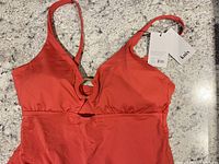 Front upper view of Knix swimsuit with hang tags visible