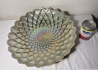 Front of iridescent embossed glass platter with can for scale