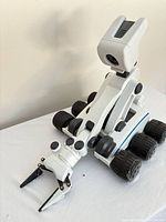 Side view of white six-wheel Mebo robot with articulated arm