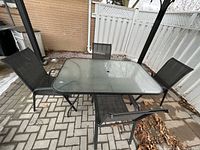 Full view of glass patio table and four chairs