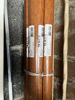 Bundle of brown wood quarter rounds with product labels visible