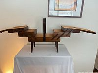 Closed view of wooden accordion sewing box on legs