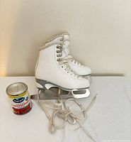 Side view of both skates showing blades and uppers, can for scale
