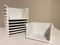 Stack of seven bins with one separate, showing form and stackability