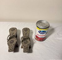 top view pair of sandals beside can for scale