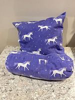 Square and bolster pillows showing matching unicorn print