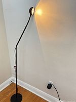 Full view of lamp standing in corner, light on