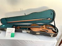 Violin in open case with bow and string package visible
