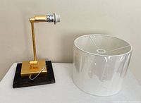 Lamp base with gold arm and separate white drum shade