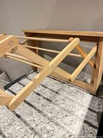 Drying rack partially extended showing scissor arms and dowels