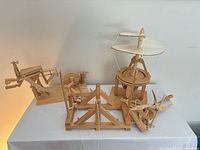 Group view of five assembled wooden da Vinci models on table