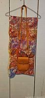 Scarf and purse hanging to show size, color and style