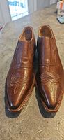 Front view of both brown leather Western dress shoes