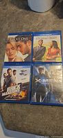 Four Blu-ray cases displayed: The Lucky One, Intolerable Cruelty, Brick Mansions, X-Men (sealed)
