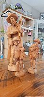 All three wooden figurines grouped on table