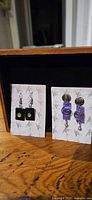 two pairs of earrings on display cards against interior of box