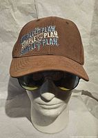 Front view showing embroidered Simple Plan logo on brown baseball cap